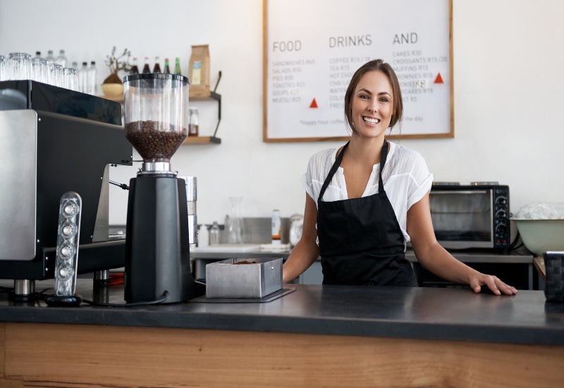 A woman stands behind the coffee shop counter in the Greater Orlando Area
