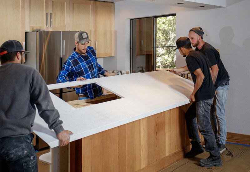 Four men collaborating on installing a kitchen countertop in the Greater Orlando Area