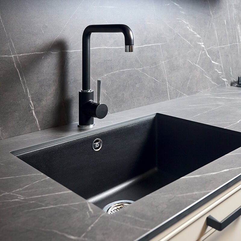 A sleek black sink sits in a kitchen with elegant marble countertops in the Greater Orlando Area